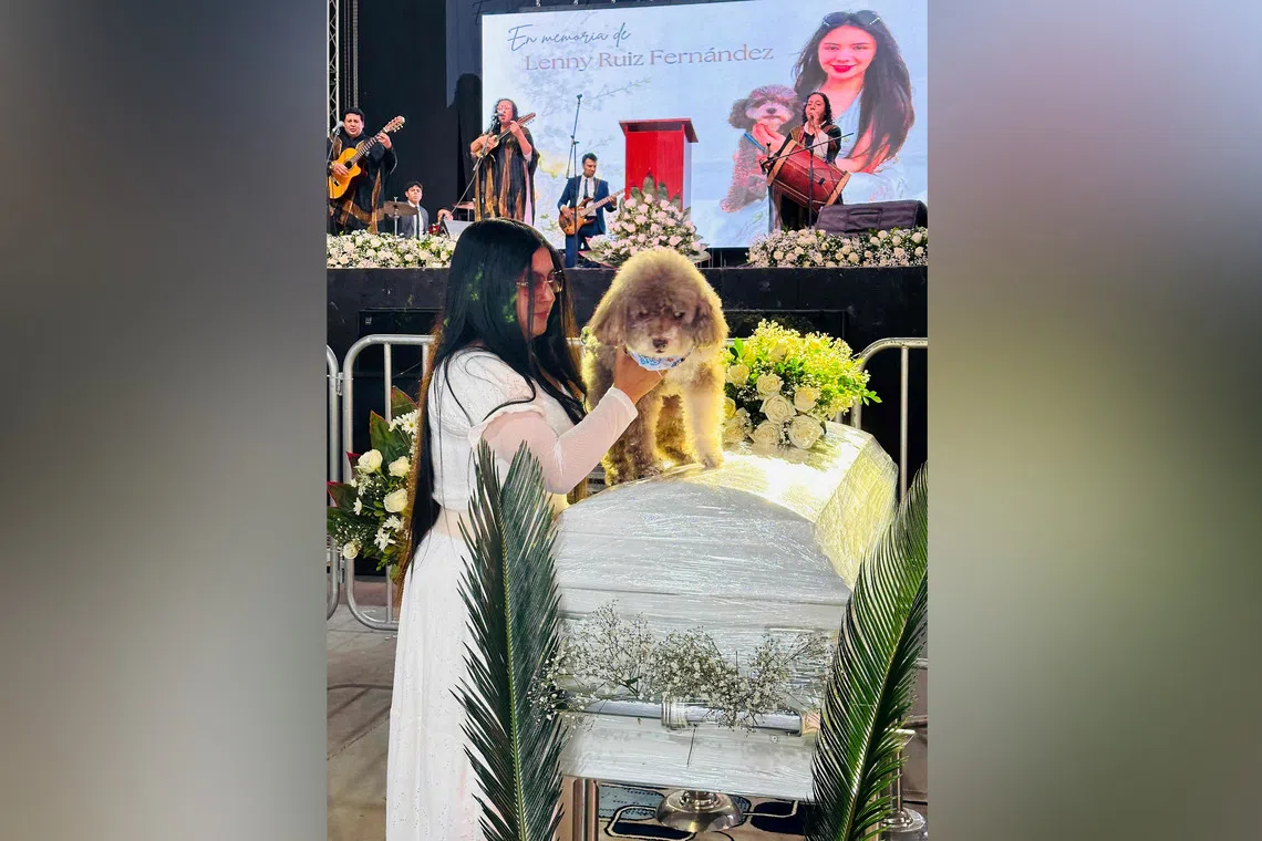 Jessica Florez, the sister-in-law of Colombian lawyer Lenny Ruiz, who died protecting her dog Salomon during the Aug 10 earthquake, with Salomon during Ruiz’s funeral on Aug 13.