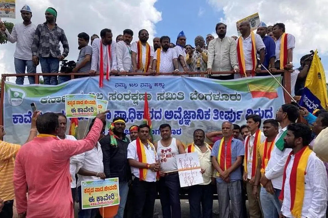 Demonstrators hold placards next to a banner at a protest against the sharing of Kaveri river water with neighbouring Tamil Nadu state, in Bengaluru, on Sept 26.
