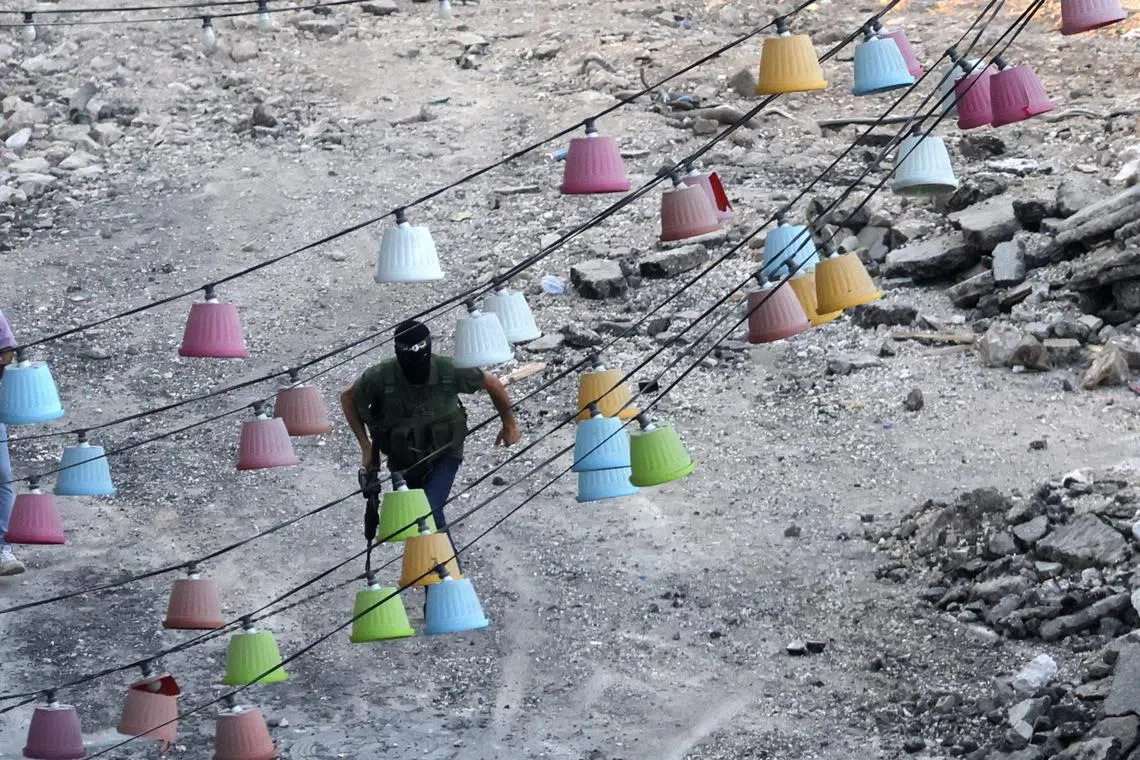 An armed Palestinian militant running for cover, during clashes with Israeli troops in the West Bank city of Jenin, on Sept 4.