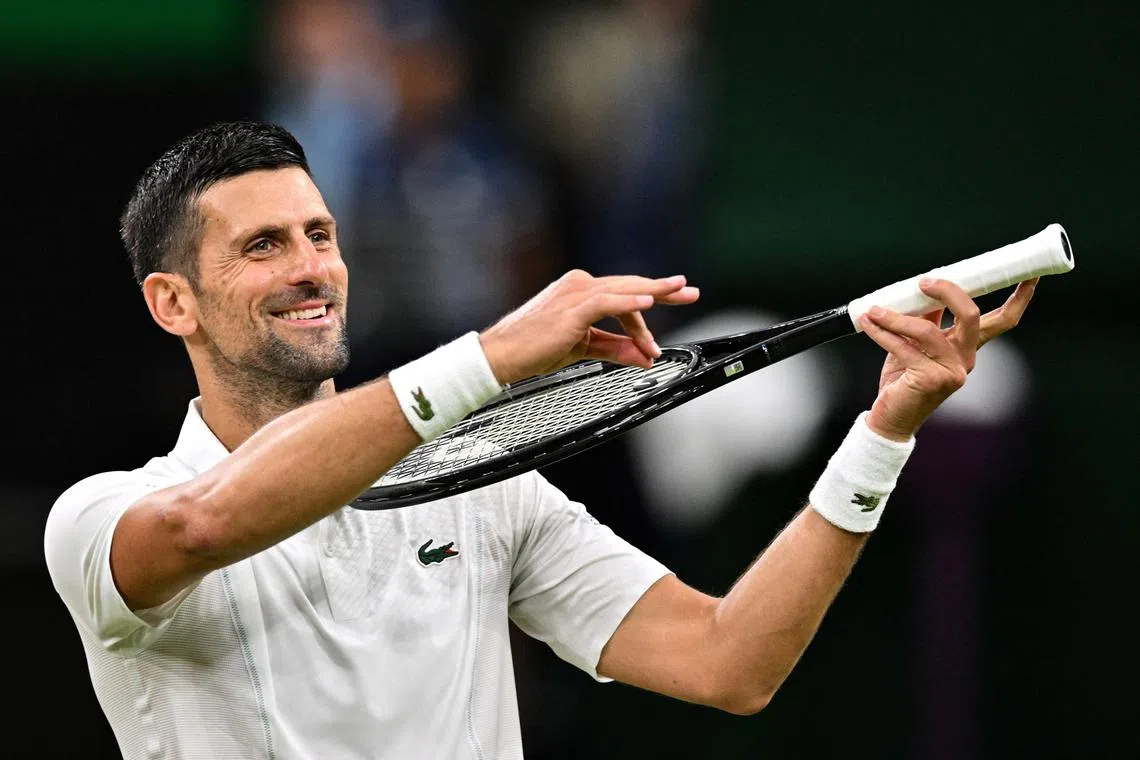 Serbia's Novak Djokovic pretends to play the violin for his daughter as he celebrates his win against Denmark's Holger Rune.