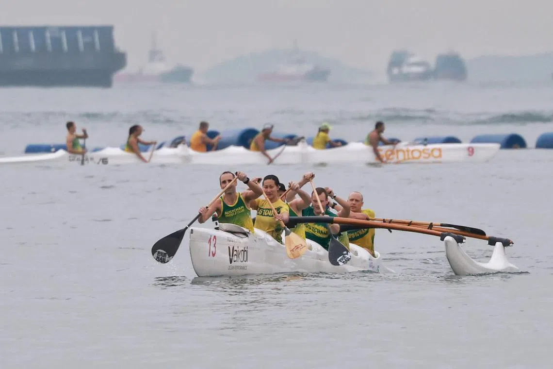 Members of Austcham Paddle Club training in a six-person canoe off Siloso beach on Sept 7, 2023. Feature on outrigger canoeing. Feature on outrigger canoeing.