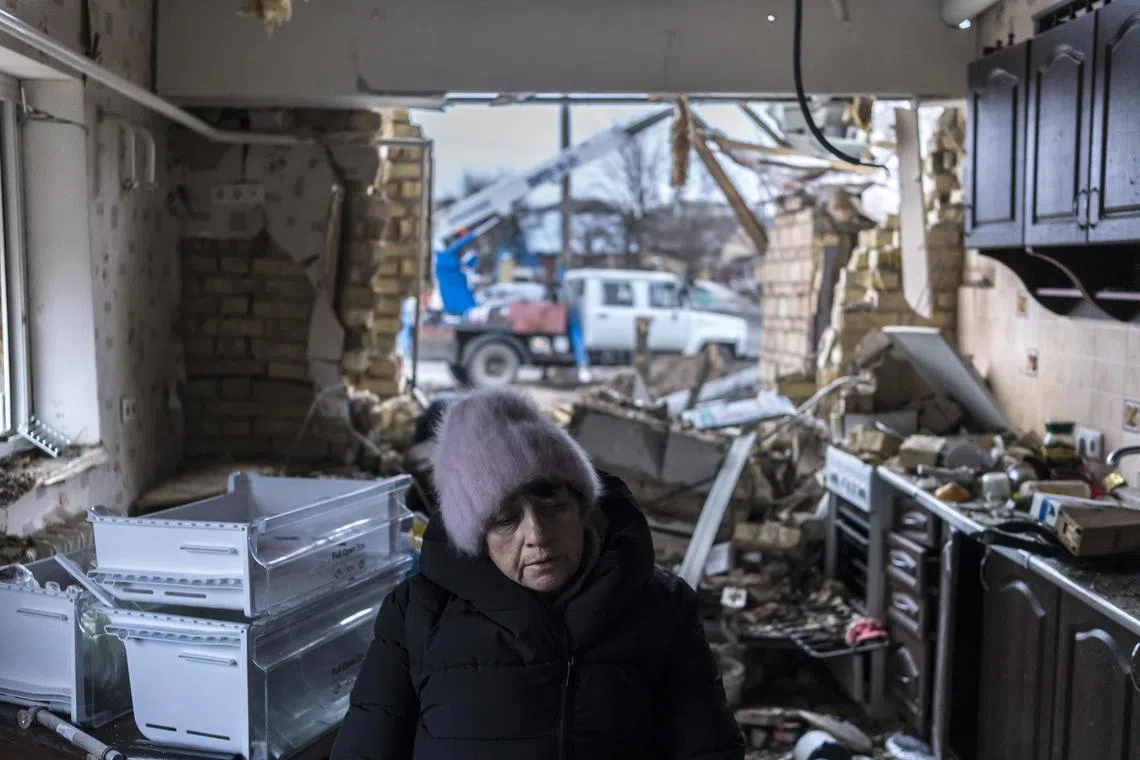 Mrs Halyna Panosyan sits in the kitchen of her home, after it was badly damaged by a Russian missile strike, in Hlevakha, Ukraine, on Jan 26, 2023.