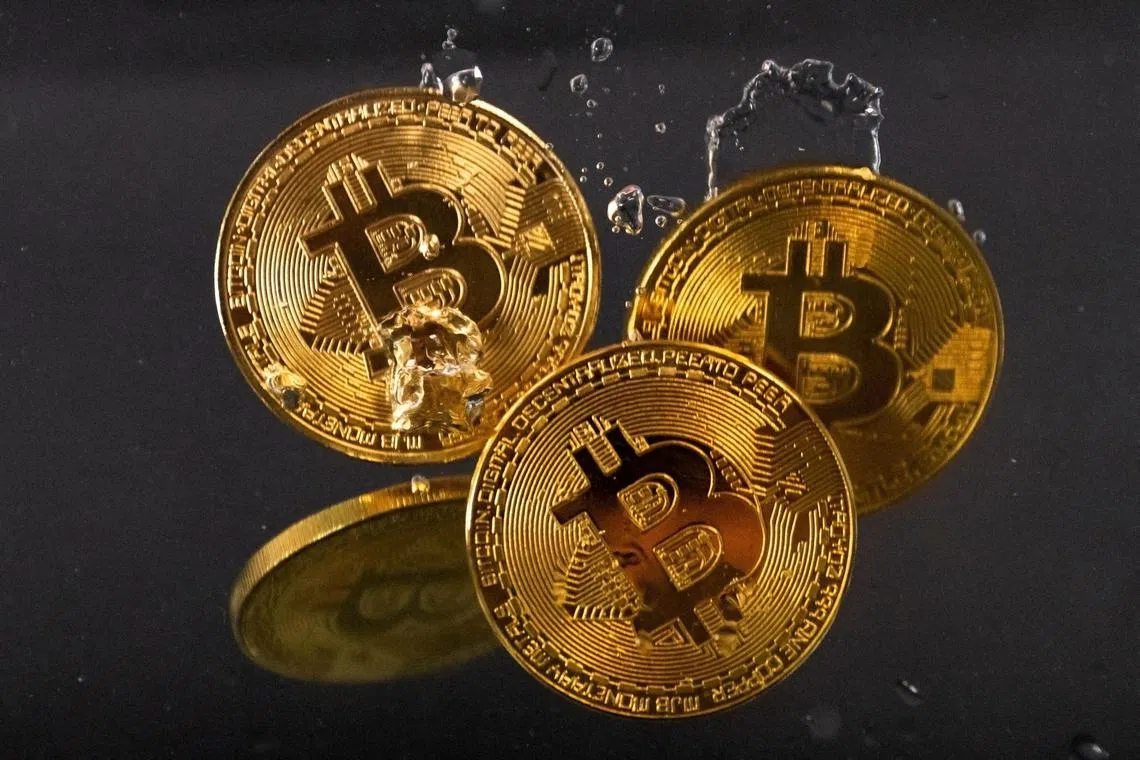 Souvenir tokens representing cryptocurrency Bitcoin plunge into water in this illustration taken May 17, 2022. REUTERS/Dado Ruvic/File Photo