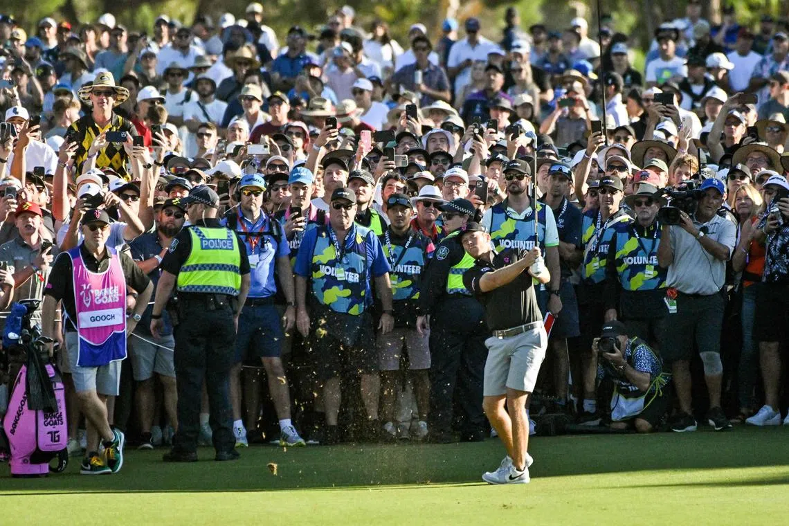 American Talor Gooch, cheered on by a massive crowd, hitting his approach to the 18th at the LIV Golf event's final round in Adelaide on April 23, 2023. 