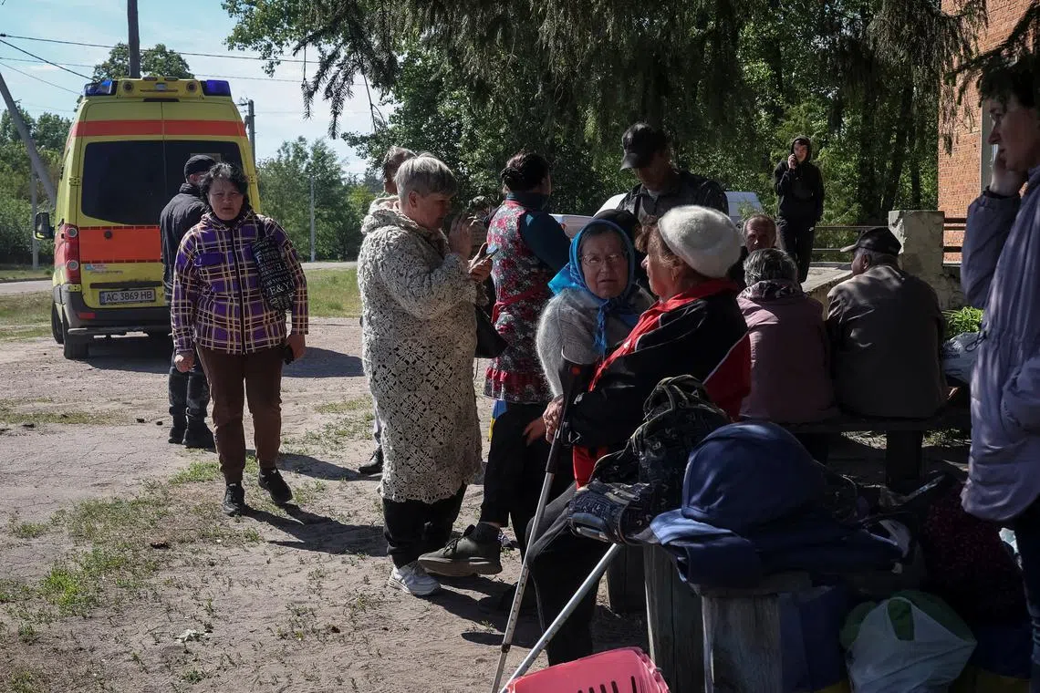 Residents from Vovchansk and nearby villages wait for buses amid an evacuation to Kharkiv due to Russian shelling, amid Russia's attack on Ukraine, at an undisclosed location near the town of Vovchansk in Kharkiv region, Ukraine May 10, 2024. REUTERS/Vyacheslav Madiyevskyy
