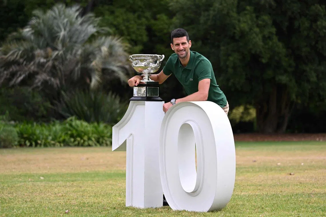 Serbia's Novak Djokovic poses with the Norman Brookes Challenge Cup trophy on Monday, a day after his 10th Australian Open singles title. 