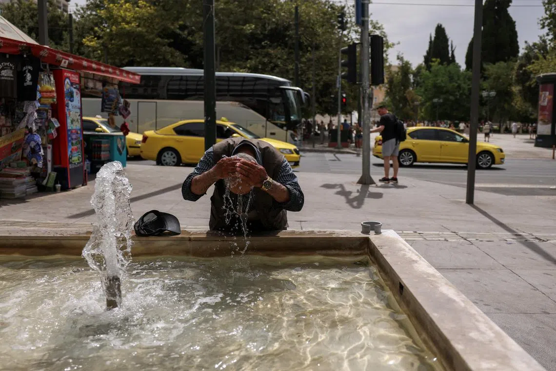 FILE PHOTO: A man cools down with water from a fountain as a heatwave hits Athens, Greece, June 13, 2024. REUTERS/Stelios Misinas/File Photo