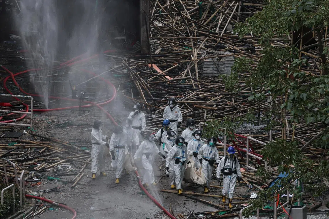 Police officers carrying the body of a victim from a fire-damaged residential block at the Wang Fuk Court housing complex, in Tai Po, Hong Kong, on Nov 30.