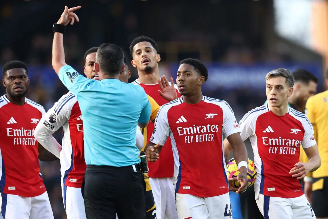 Arsenal midfielder Myles Lewis-Skelly (second from right) reacts after being sent off by English referee Michael Oliver, during their Premier League match against Wolves.