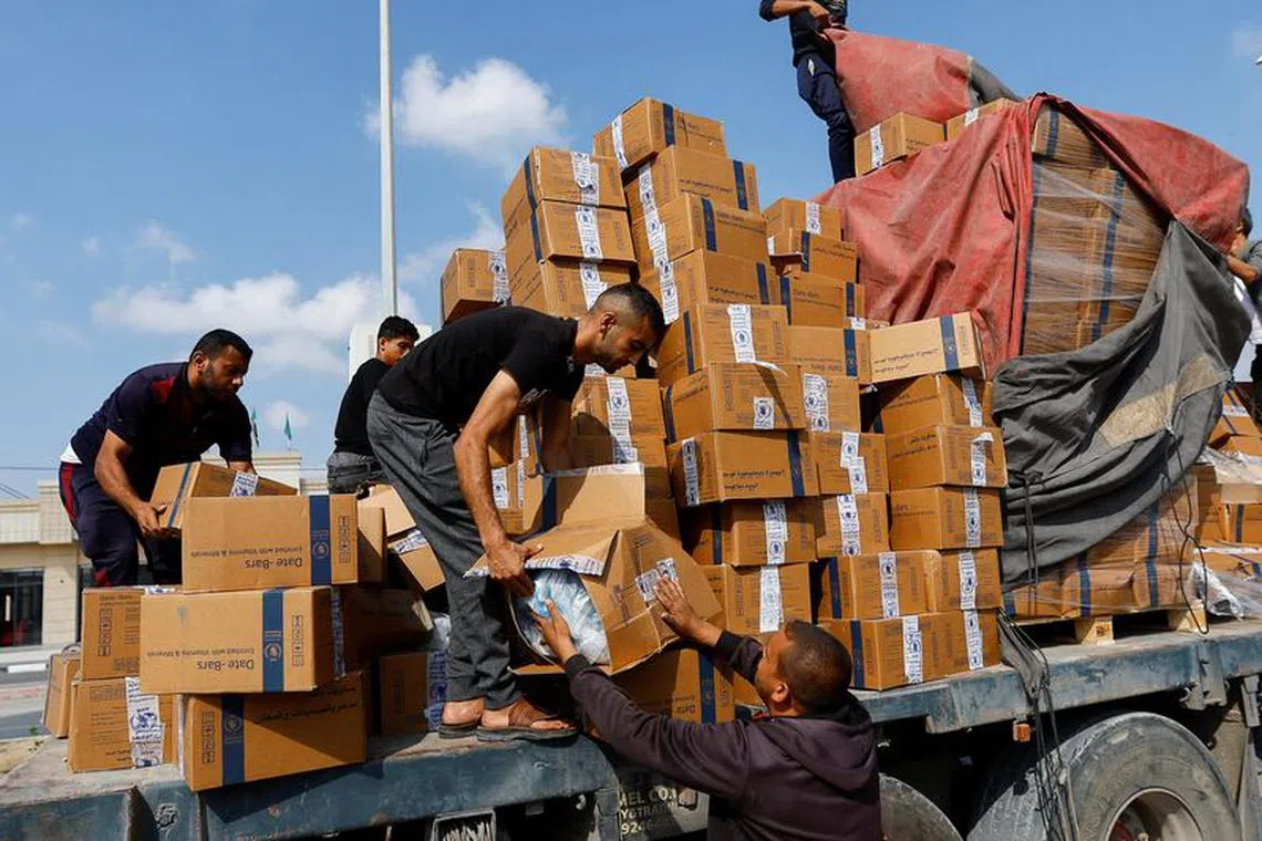Palestinians reload a truck with aid that fell from the vehicle, amid shortages of food supplies, during the ongoing conflict between Israel and Palestinian Islamist group Hamas, in Rafah in the southern Gaza Strip, November 2, 2023. REUTERS/Ibraheem Abu Mustafa/ File Photo