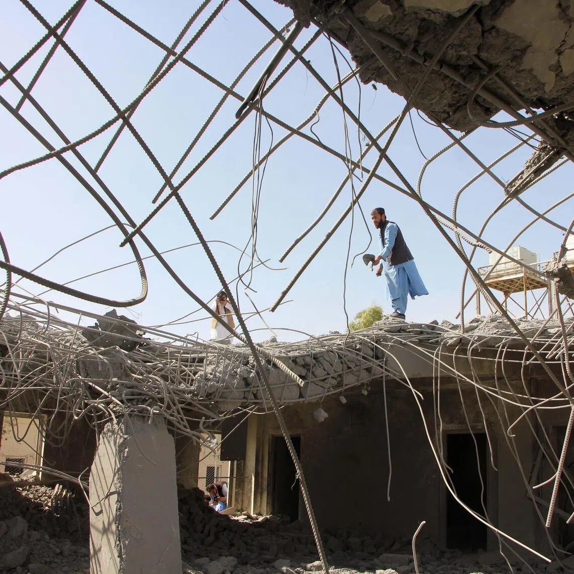 People survey a damaged area following reported Pakistani airstrikes in Kandahar, Afghanistan, on March 15.