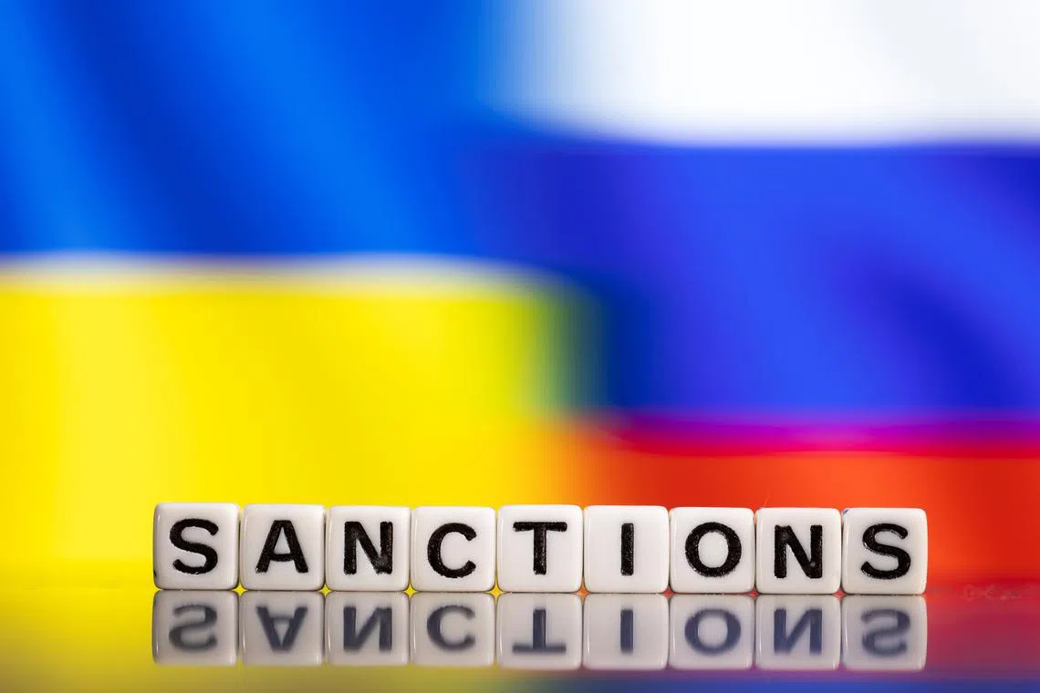 Plastic letters arranged to read \"Sanctions\" are placed in front of Ukraine's and Russia's flag colors  in this illustration taken February 25, 2022. REUTERS/Dado Ruvic/Illustration/ File photo