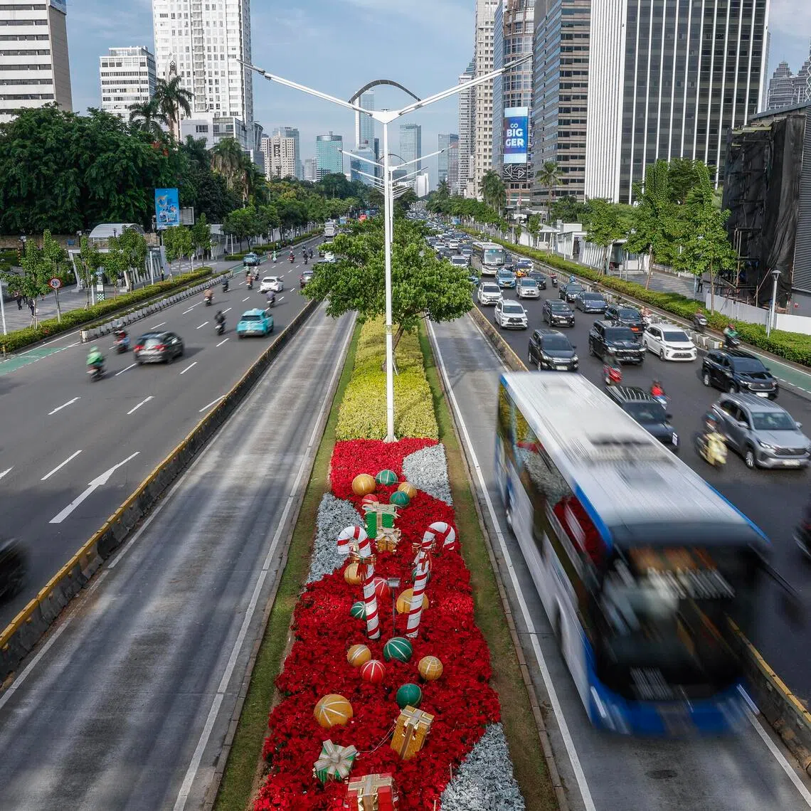 Vehicles pass a Christmas decoration on a busy street in Jakarta, Indonesia, on Dec 22, 2025.