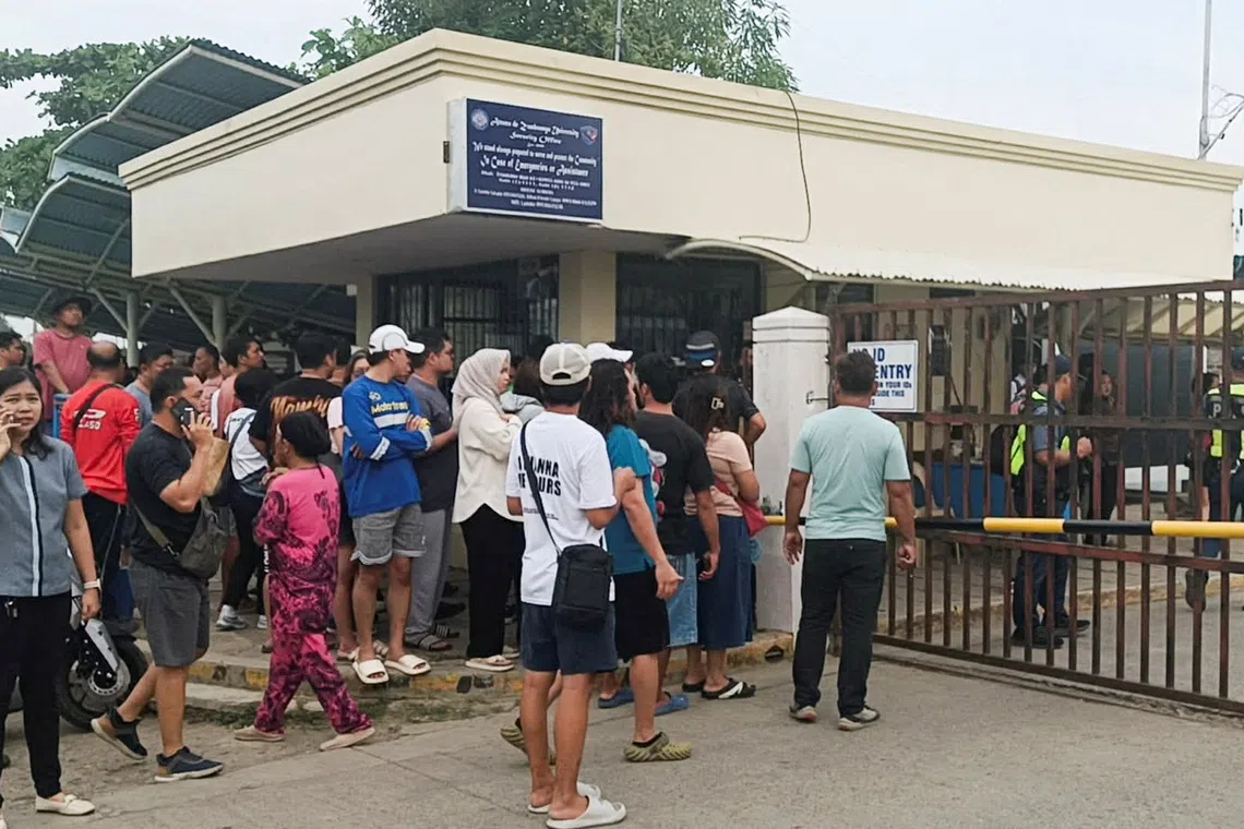 People stand outside Ateneo de Zamboanga University after a shooting that killed two people, in Zamboanga, southern Philippines, August 18, 2026. REUTERS/Nonoy Lacson
