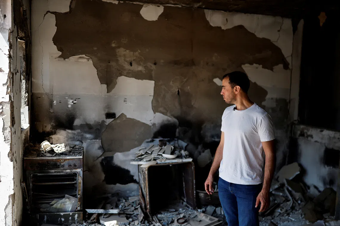 Tal Shoham, a former hostage who was kidnapped by Hamas on October 7, 2023, with his wife and two children as well as three other members of his family, and held in Gaza for 505 days, looks at the damage to the home of his in-laws in Kibbutz Beeri, southern Israel, September 15, 2025. REUTERS/Amir Cohen
