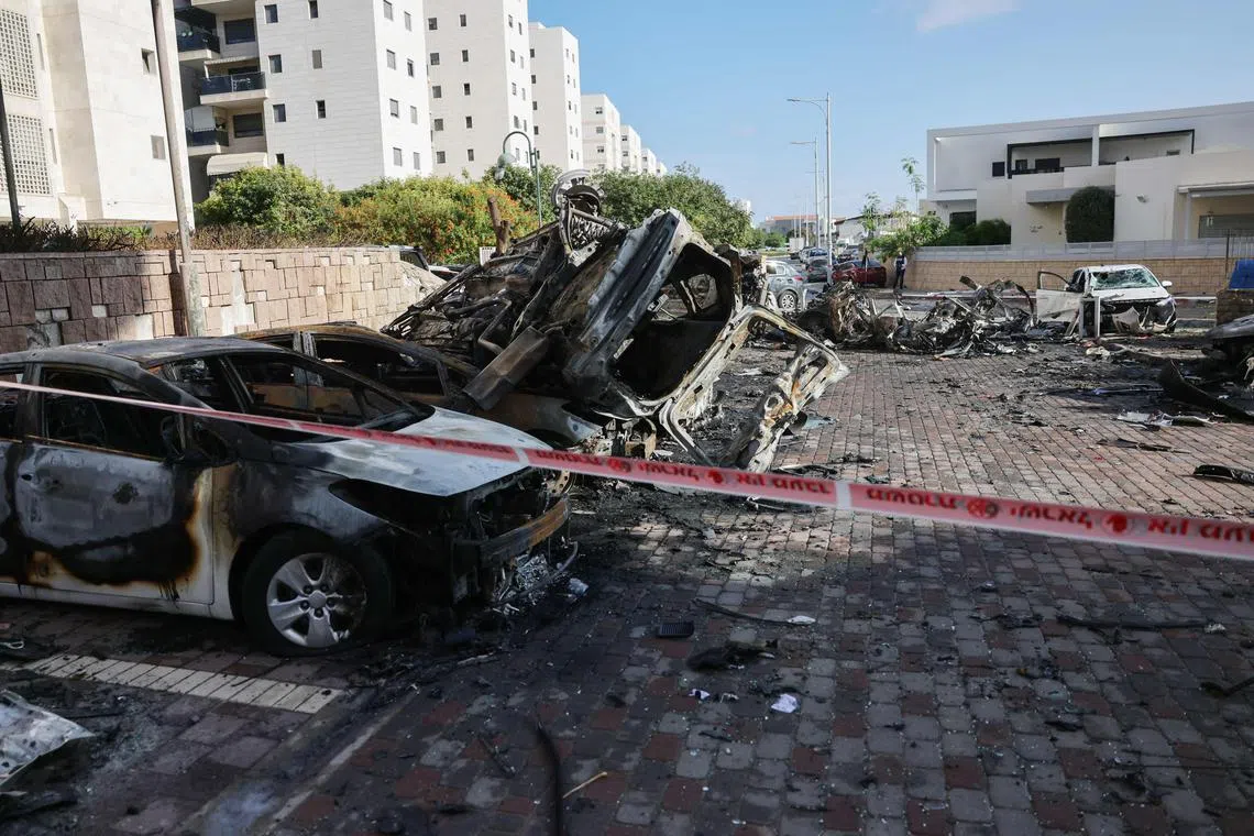 Burnt out vehicles are seen outside a residential building hit in a rocket attack from the Gaza Strip, on Oct 7.