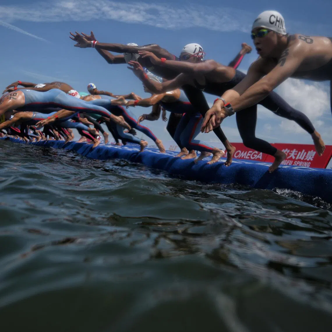 Competitors dive into the water during the Men’s Open Water 10km final at Sentosa’s Palawan Beach on July 16, 2025. The event had been pushed back from 8am to 1pm due to elevated levels of E. coli in the water exceeding acceptable thresholds.