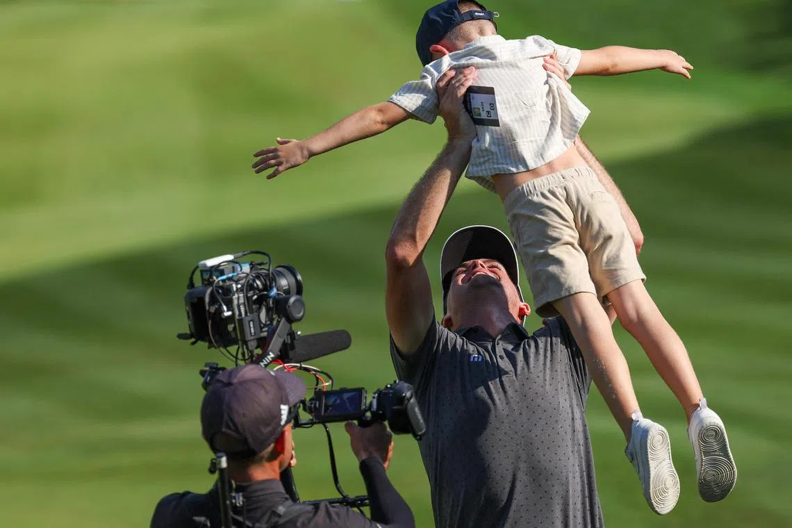 An overjoyed Keegan Bradley  celebrating with his son on the 18th green after winning the Travelers Championship on Sunday. 