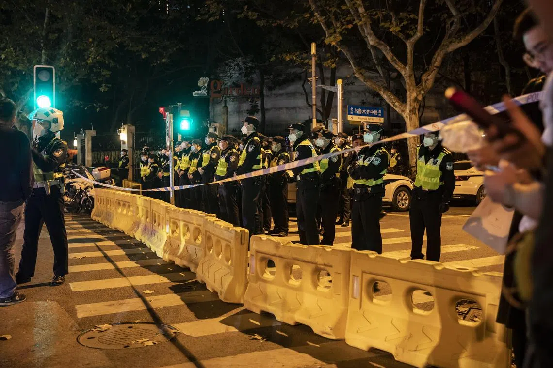 Police officers block a street where protests had taken place the night before, in Shanghai, China, on Nov 27, 2022.