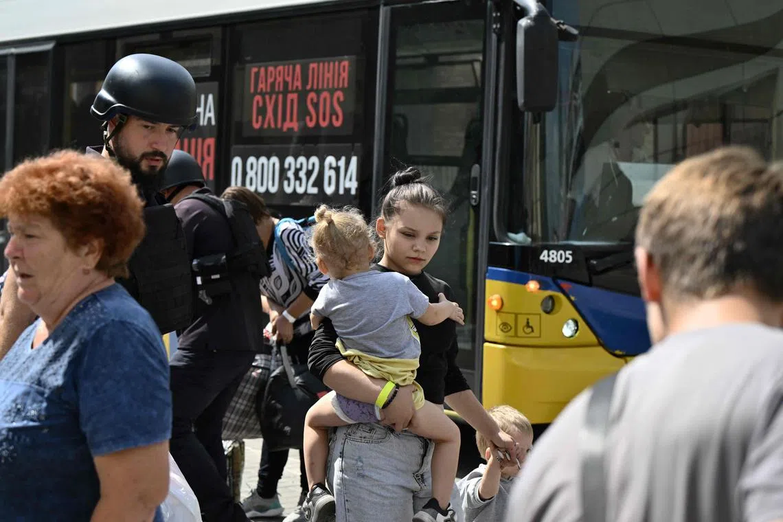 People arrive by a bus to board an evacuation train at an undisclosed location in Donetsk region, Ukraine, on Aug 26.