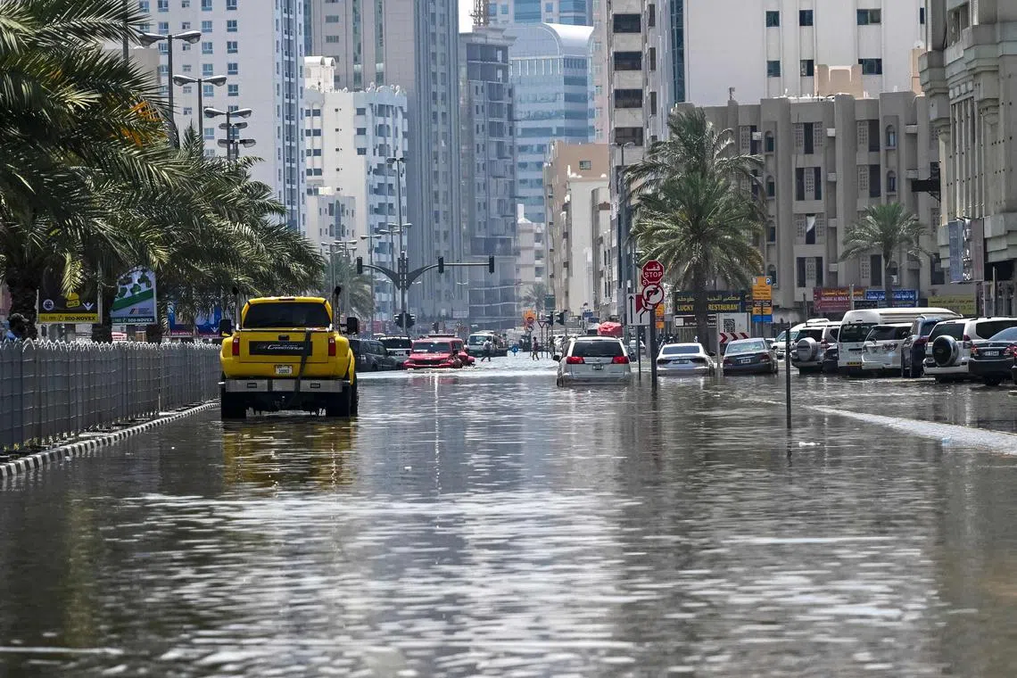 A car driving down a flooded street in Sharjah, on April 20, 2024. Four people died after the heaviest rainfall on record in the oil-rich UAE on April 16.