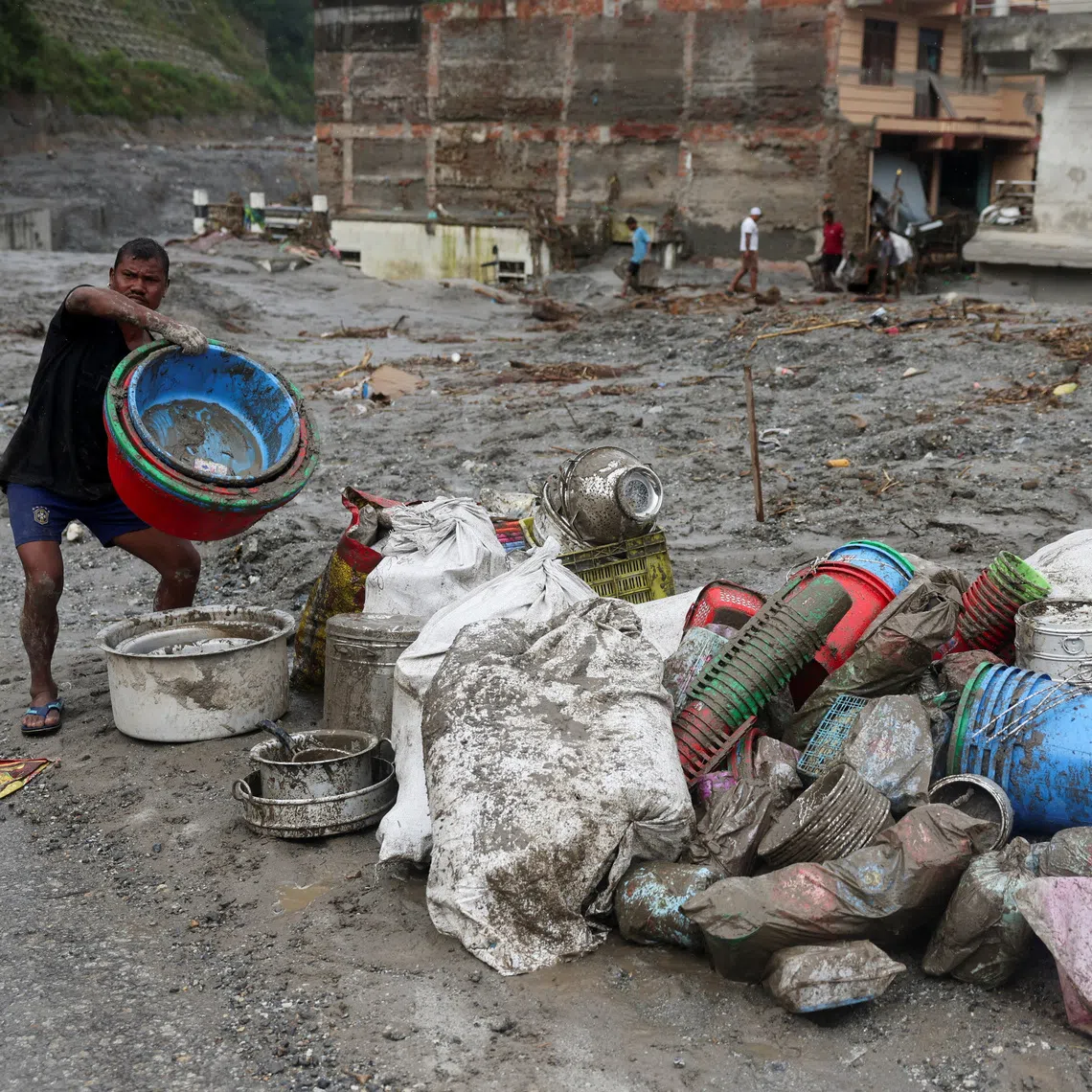 A man gathers belongings retrieved from a damaged house after flash floods and mudslides, in Devighat, Nuwakot district, Nepal, on Aug 29.