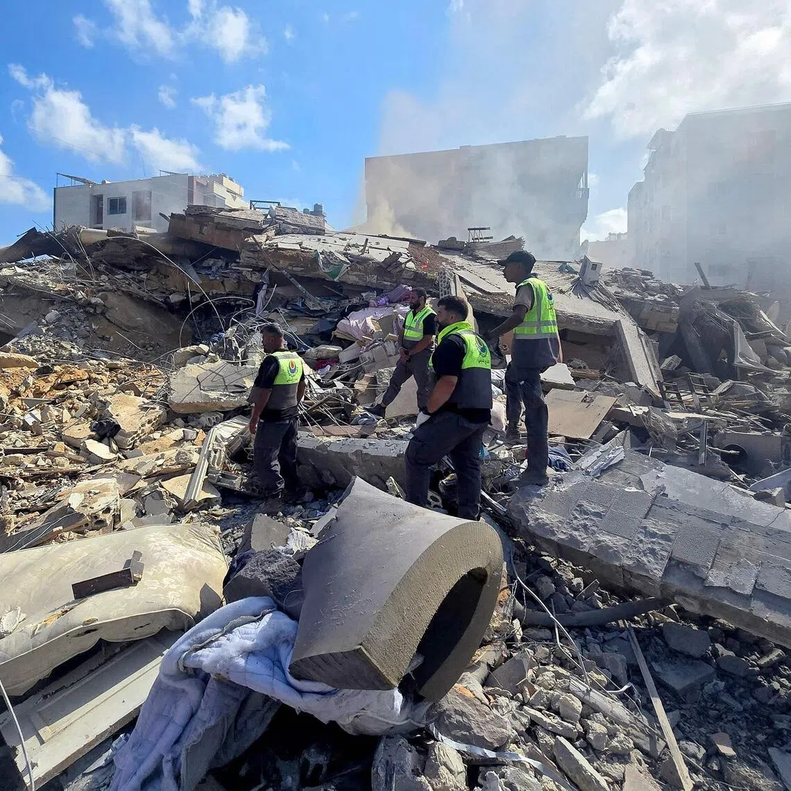 Lebanese civil defence workers search through the rubble of a building following an Israeli strike at dawn near the coastal city of Tyre in southern Lebanon on May 26.