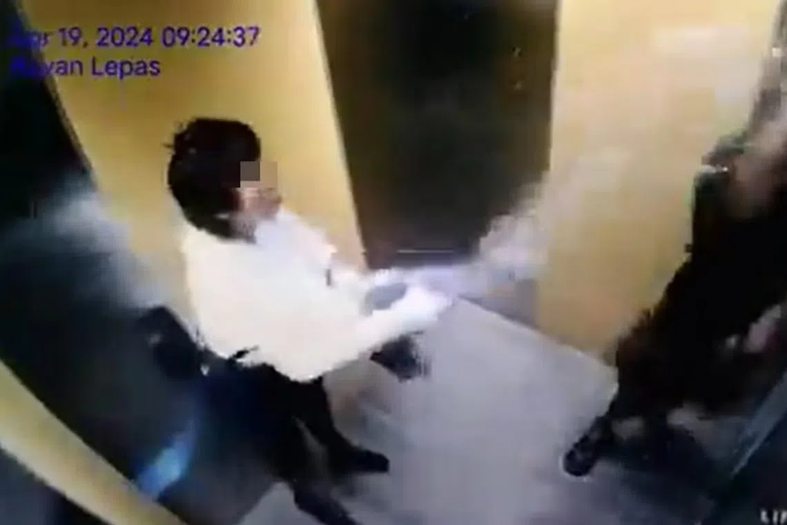Video footage of a woman splashing water on a man in an apartment building lift. 