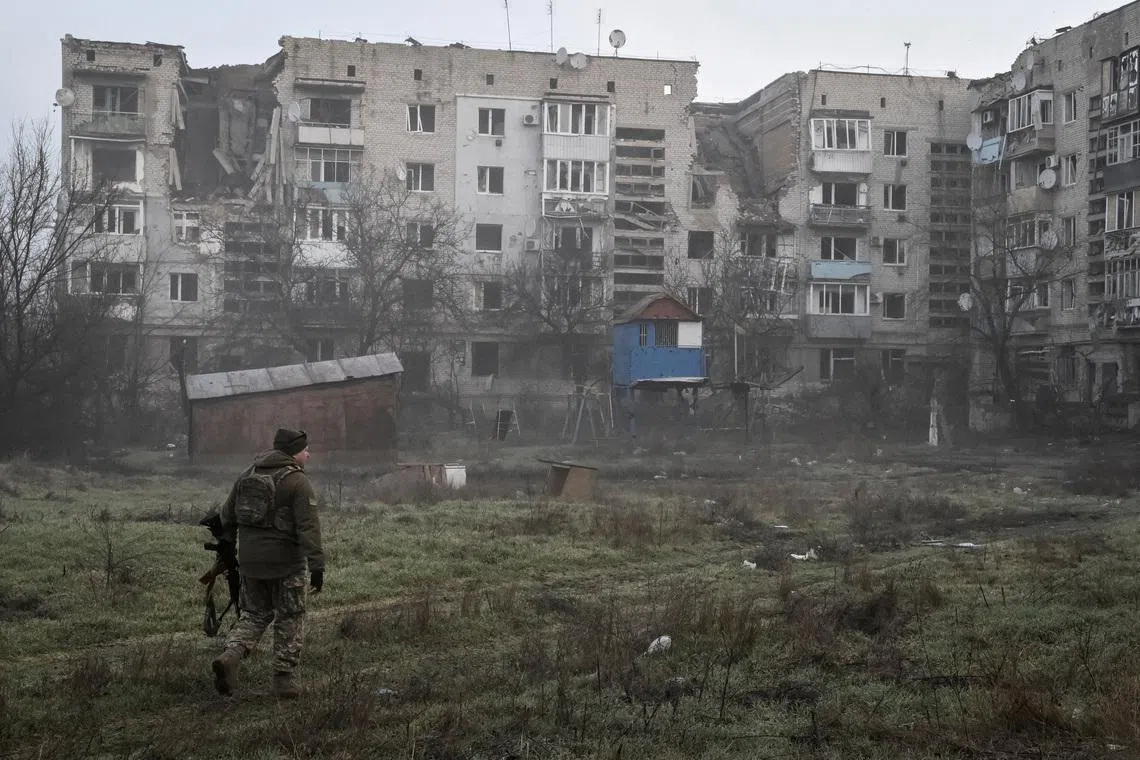 A Ukrainian service member walks near residential buildings damaged by Russian military strikes, amid Russia's attack on Ukraine, in the frontline town Orikhiv in Zaporizhzhia region, Ukraine March 26, 2026.