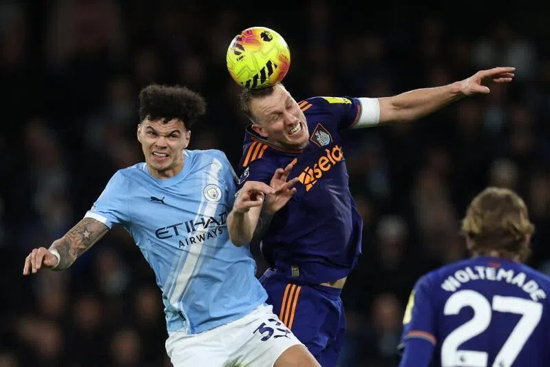 Manchester City's English midfielder Nico O'Reilly (left) vies with Newcastle United's English defender Dan Burn during the match.