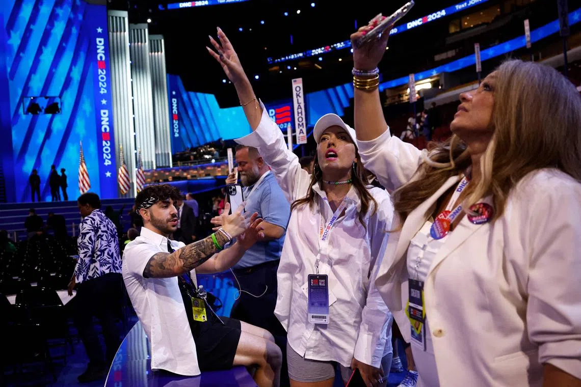 Social media influencers wearing white produce content during the final day of the Democratic National Convention in Chicago.