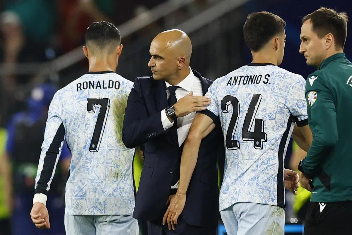 FILE PHOTO: Soccer Football - Euro 2024 - Group F - Georgia v Portugal - Arena AufSchalke, Gelsenkirchen, Germany - June 26, 2024  Portugal's Cristiano Ronaldo with coach Roberto Martinez after being substituted REUTERS/Leon Kuegeler/File Photo