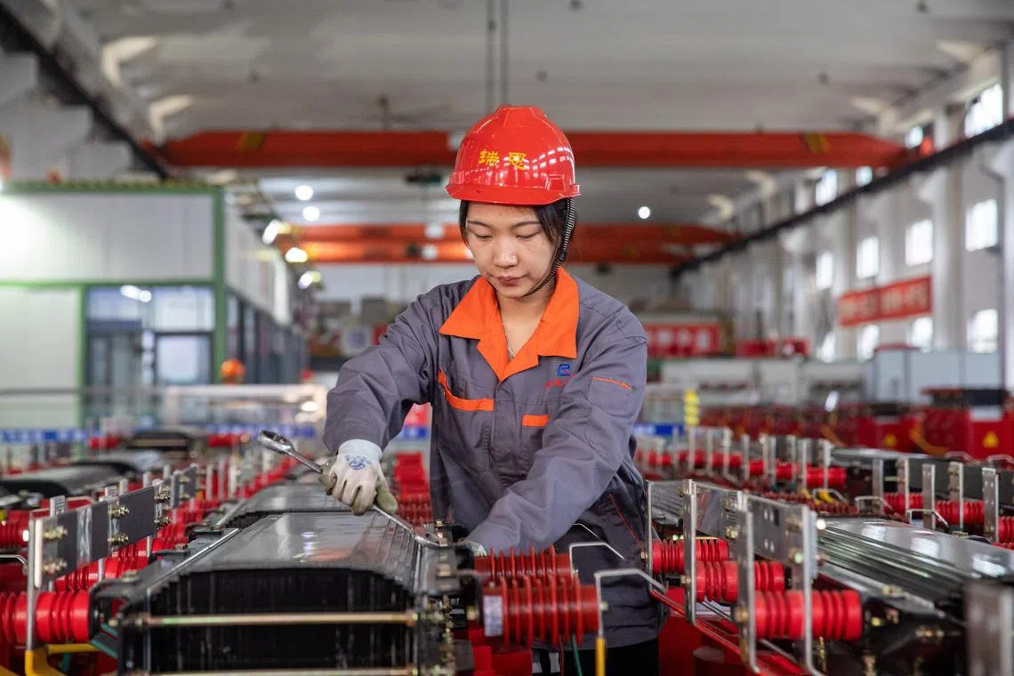 This photo taken on November 17, 2022 shows a worker manufacturing transformers at a factory in Haian in China's eastern Jiangsu province. (Photo by AFP) / China OUT