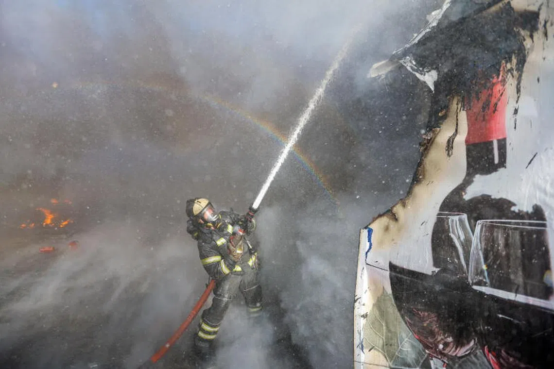 A firefighter works to extinguish fire at market stalls hit by shelling in the course of Russia-Ukraine conflict in Donetsk, Russian-controlled Ukraine on December 6, 2022. PHOTO : REUTERS