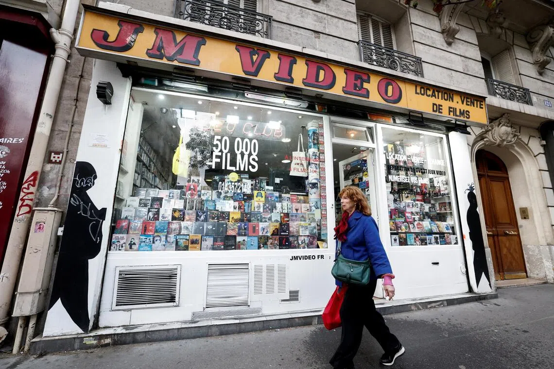 FILE PHOTO: A pedestrian walks past JM Video, a video rental store, which is facing financial difficulties, in Paris, France, September 13, 2025. REUTERS/Benoit Tessier/File Photo