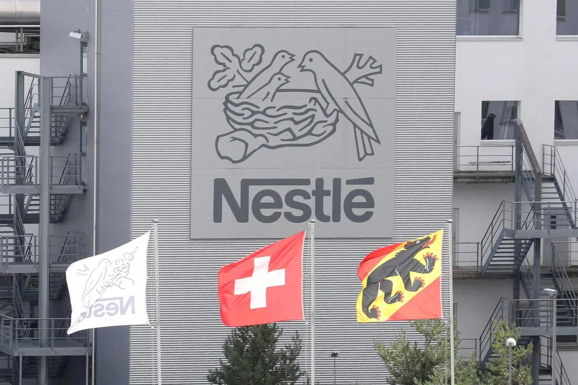 FILE PHOTO: A Swiss national flag flies beside a flag of the canton of Bern in front of the logo of Nestle at a plant in Konolfingen, Switzerland September 28, 2020. REUTERS/Arnd Wiegmann//File Photo