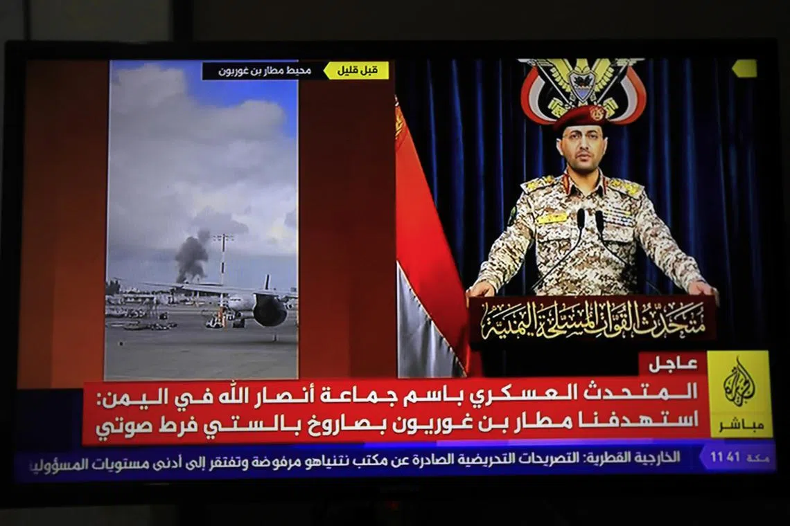 A person watching Houthi military spokesman Yahya Sarea delivering a televised statement about a missile attack on Israel's Ben Gurion airport on May 4. The Iran-backed group claimed responsibility for the attack. 