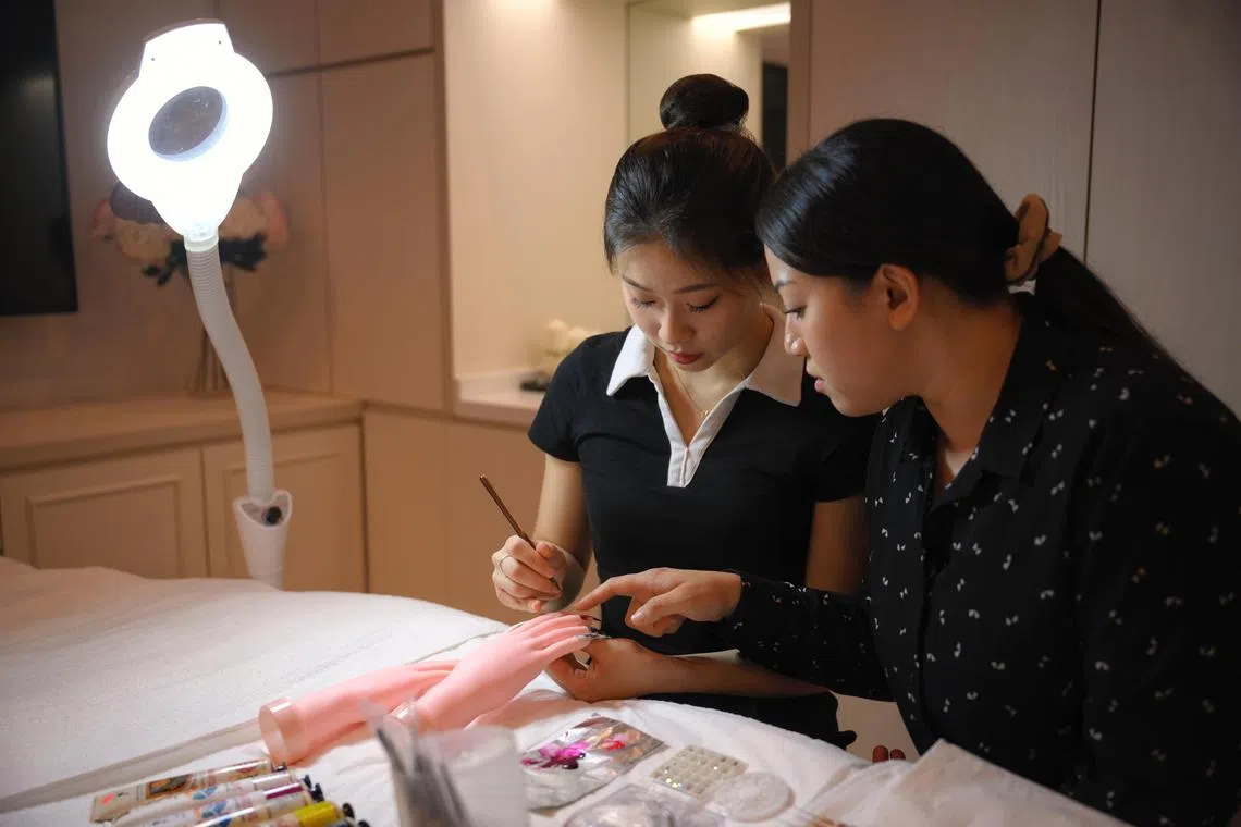Shuner Villanueva Leong (right), 34, a beauty and wellness lecturer at ITE College East and Christine Huang, 20, a year 1 student doing a Technical Diploma in Beauty and Wellness Management at ITE College East, pictured on August 22, 2024. 