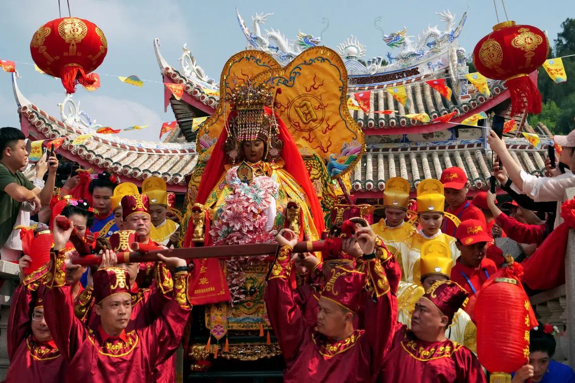 Pilgrims carry a sedan chair holding a statue of the sea goddess Mazu out of a temple during a pilgrimage on Meizhou island, Fujian province, China October 11, 2024. REUTERS/Xiaoyu Yin