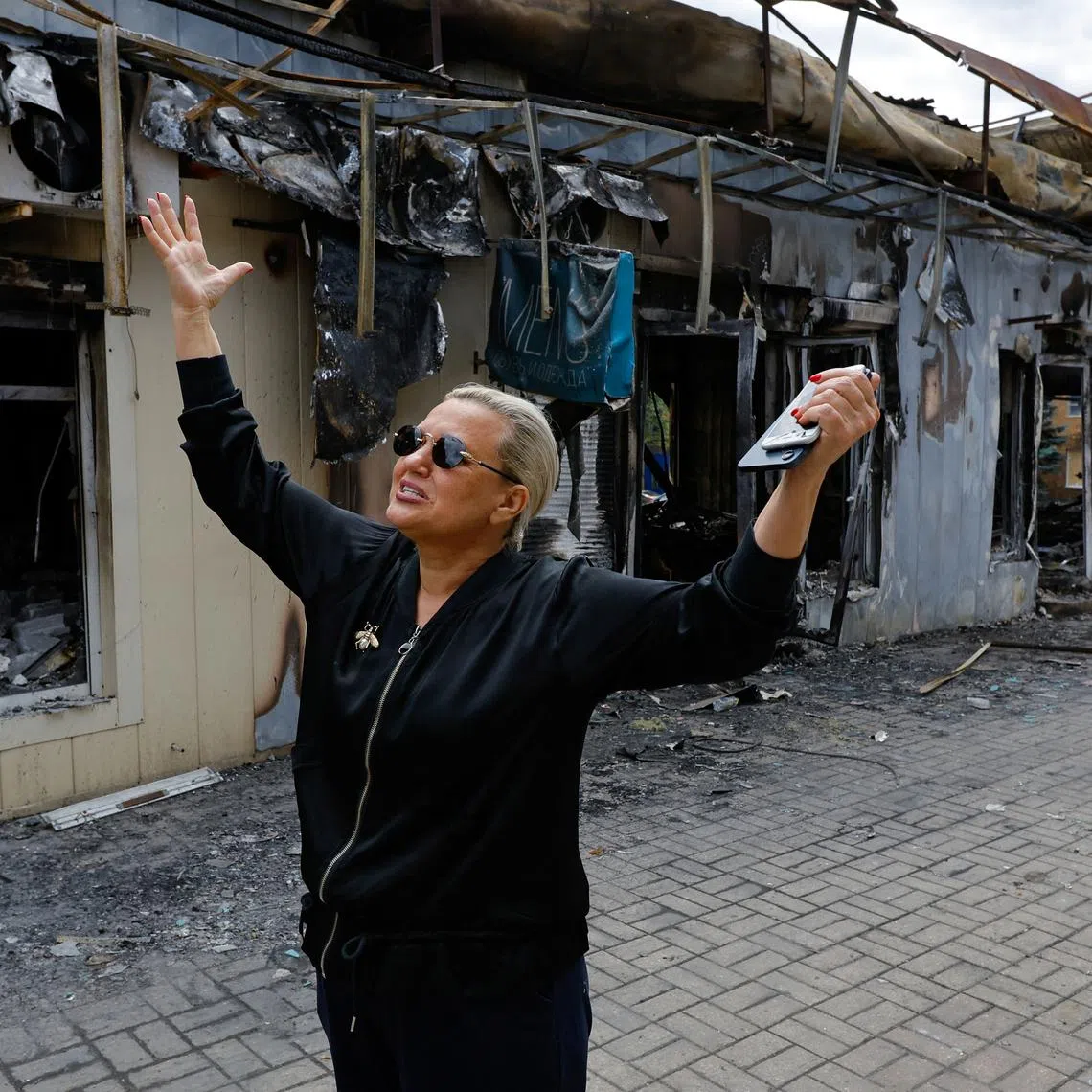 Shop owner Tamara Pozdnyakova, 58, speaks in front of the shops damaged by shelling of the market on 30 June in what local Russian-installed authorities called a Ukrainian military strike, in the course of Russia-Ukraine conflict in Donetsk, a Russian-controlled city of Ukraine, July 3, 2025. REUTERS/Alexander Ermochenko