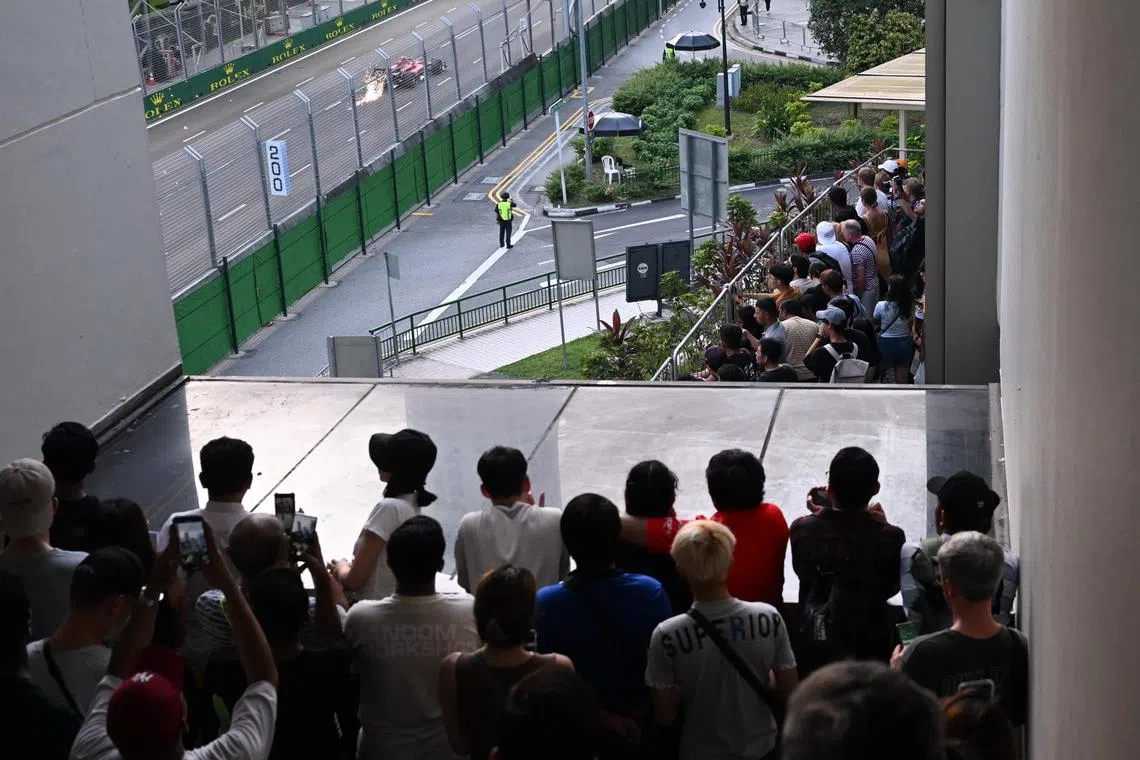 Fans try to catch a gimpse of the Formula One cars during the practice laps from the open and unblocked area at Marina Square on the second day of the Singapore Grand Prix on September 16. 

ST PHOTO AZMI ATHNI