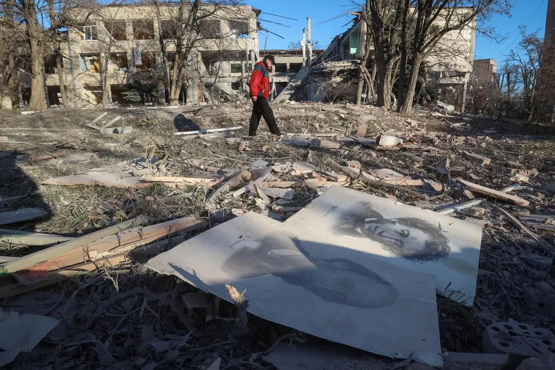 A resident walking near a school building destroyed during Russian air strikes, on Nov 25, in the town of Slovyansk, in Ukraine's Donetsk region.