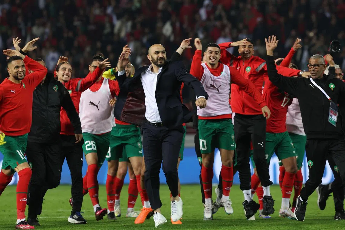 Morocco's coach Walid Regragui (centre) and his players greet the fans after the friendly football match between Morocco and Brazil at the Ibn Batouta Stadium in Tangier on March 26, 2023. (Photo by Fadel Senna / AFP)