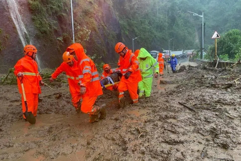 epa12398458 A handout photo made available by Tuba Public Information Office (PIO) shows rescuers carrying a victim in the landslide-hit municipality of Tuba, Benguet province, Philippines, 22 September 2025. At least one motorist was killed and several were injured when a landslide occurred along a highway in Tuba, due to the Super Typhoon Ragasa, locally known as Nando, currently affecting the northern Philippines, according to Tuba Public Information Office.  EPA/TUBA PUBLIC INFORMATION OFFICE HANDOUT HANDOUT EDITORIAL USE ONLY/NO SALES