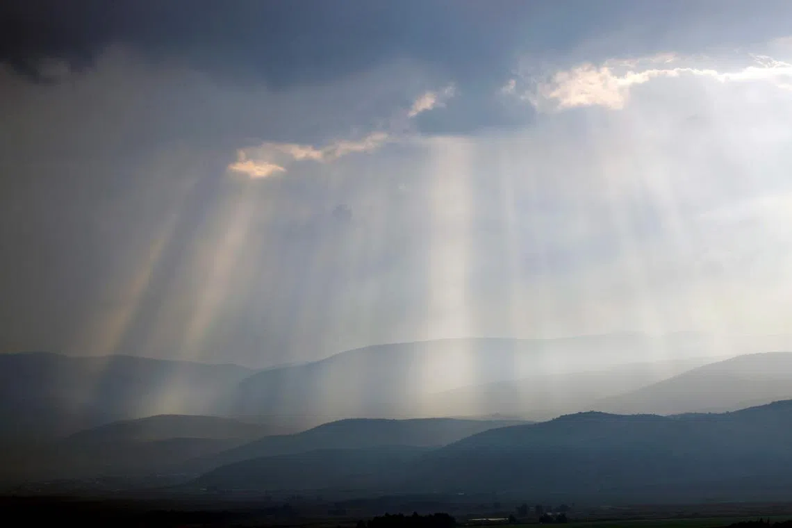 Sunlight breaks through the clouds on the hills of Ramim Ridge in Upper Galilee in northern Israel near the Lebanon border on January 2, 2024, amid ongoing cross-border tensions as fighting continues between Israel and Hamas militants in Gaza. (Photo by jalaa marey / AFP)