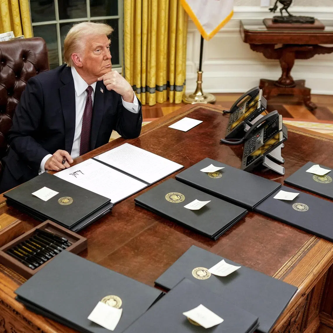 President Donald Trump pauses while signing  executive orders in the Oval Office of the White House in Washington on Monday, Jan. 20, 2025, following his inauguration as the 47th president. (Doug Mills/The New York Times)