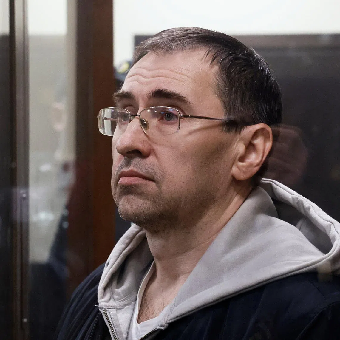 Oleg Roldugin, an investigative journalist for the independent Russian newspaper Novaya Gazeta, who was detained in a case involving alleged misuse of personal data, stands inside an enclosure for defendants before a court hearing in Moscow, Russia April 10, 2026. REUTERS/Stringer