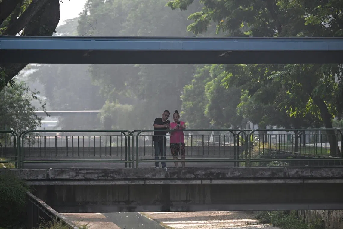 A couple on a bridge at 8.50am in Toa Payoh on Oct 7. The 24-hr PSI Reading was about 97 according to NEA.