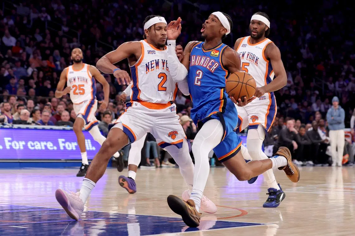 Oklahoma City Thunder guard Shai Gilgeous-Alexander drives to the basket against New York Knicks guard Miles McBride and forward Precious Achiuwa during the first quarter at Madison Square Garden.