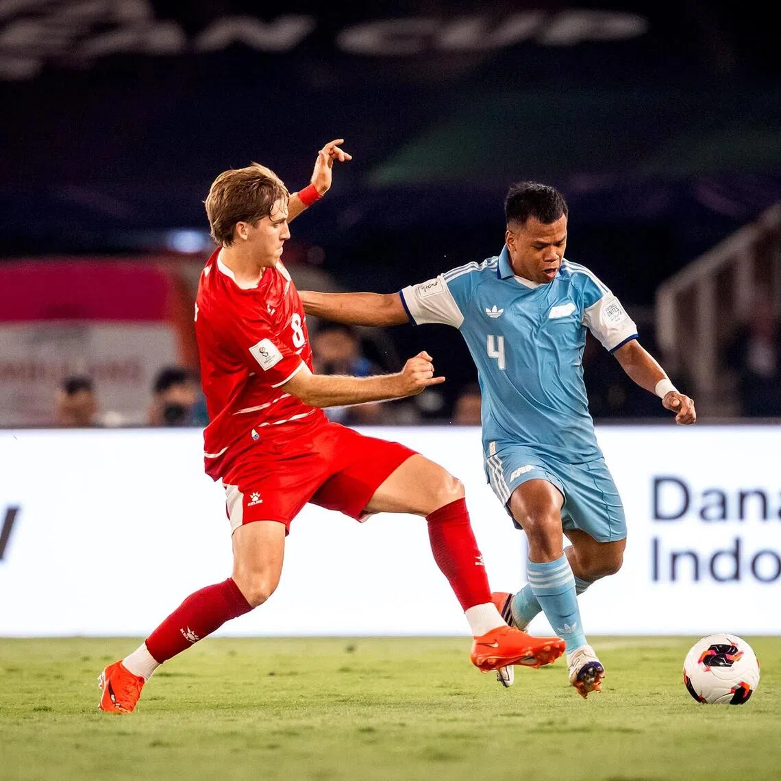 Lions defender Nur Adam Abdullah (right) taking on Indonesia’s Luke Vickery.